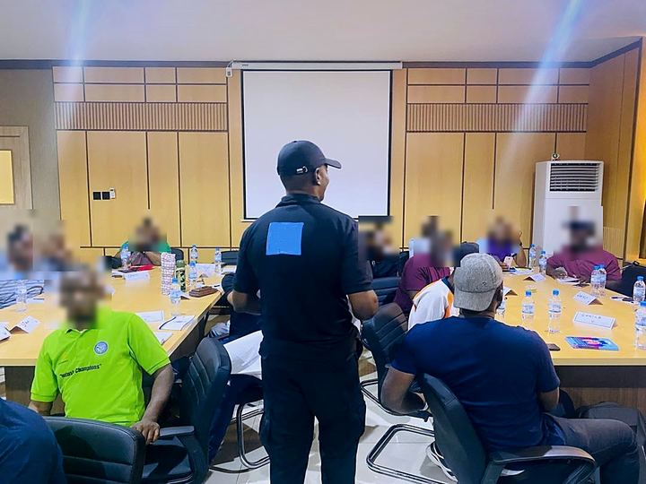 An Apabet trainer standing in front of a seated training group in a conference room